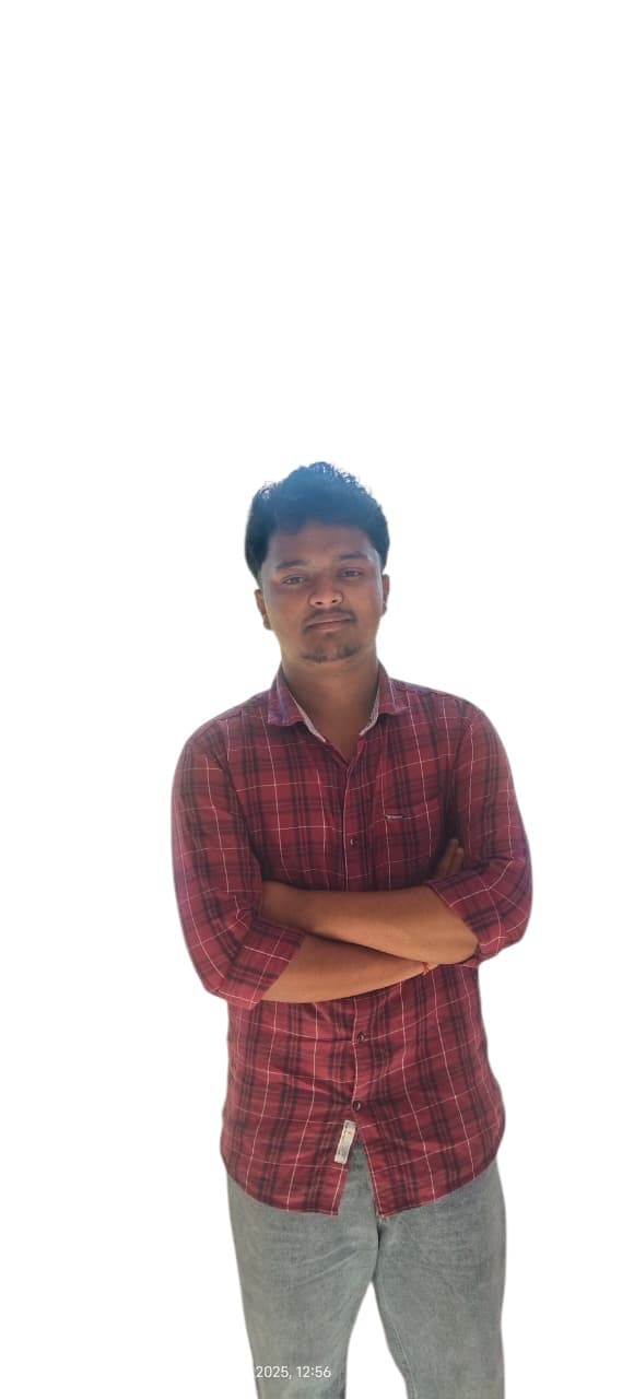 लाल और काली चेक शर्ट पहने हुए एक युवक हाथ बांधकर खड़ा है।