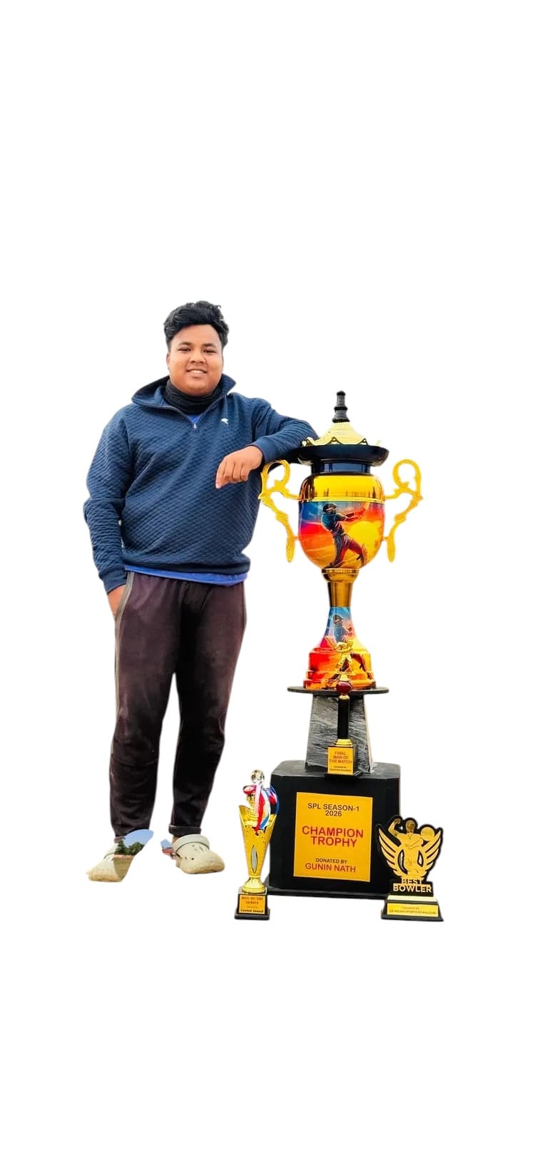 नीली हुडी पहने मुस्कुराता युवक बड़ी सुनहरी क्रिकेट चैंपियनशिप ट्रॉफी और पुरस्कारों के साथ।